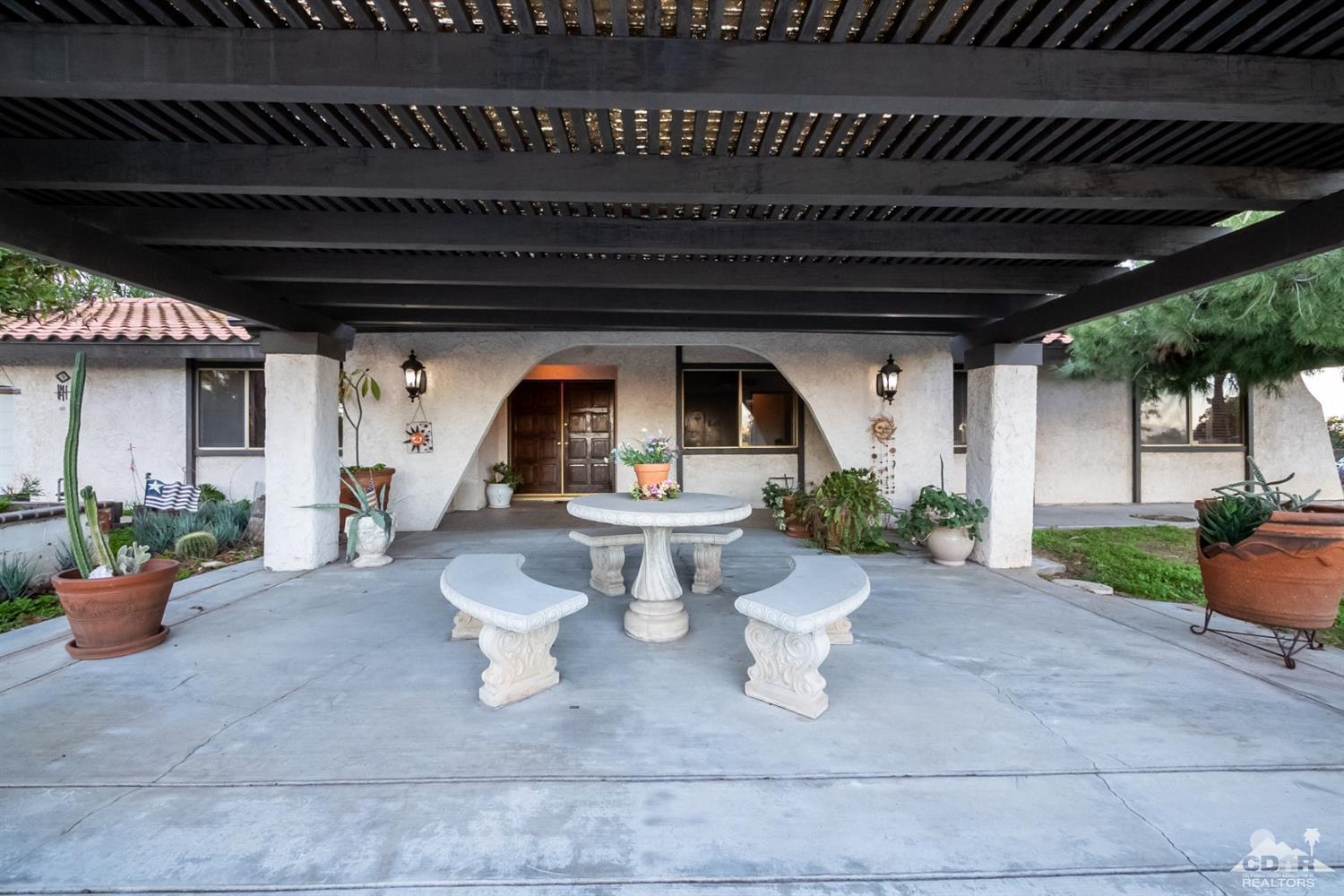 2132 John Street Riverside, CA 92503 - Photo 48 of 52 a view of a patio with table and chairs potted plants and floor to ceiling window