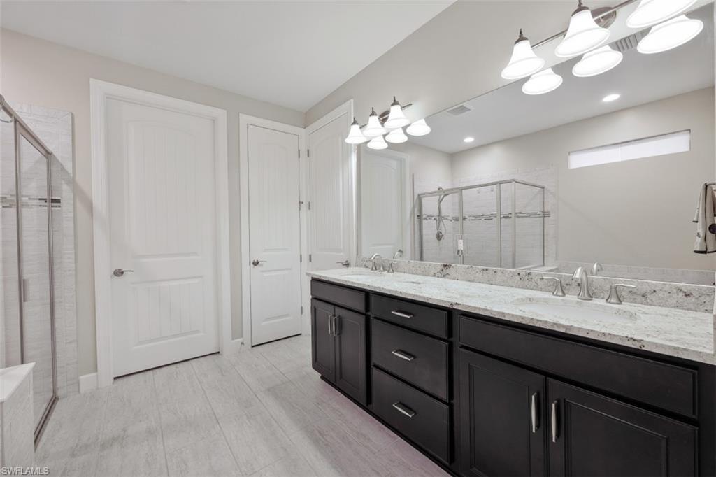 9431 Greyhawk Trail Naples, FL 34120 - Photo 19 of 50 a bathroom with a double vanity sink and a mirror