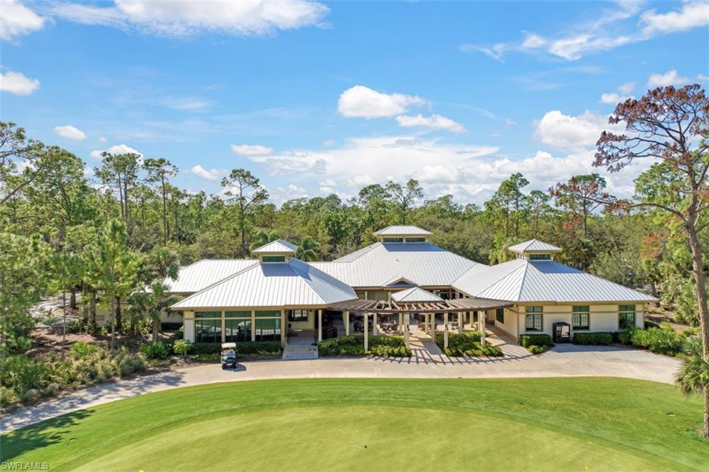 9431 Greyhawk Trail Naples, FL 34120 - Photo 41 of 50 a patio with a table and chairs under an umbrella