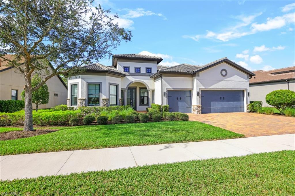 9431 Greyhawk Trail Naples, FL 34120 - Photo 42 of 50 a front view of a house with a yard and garage