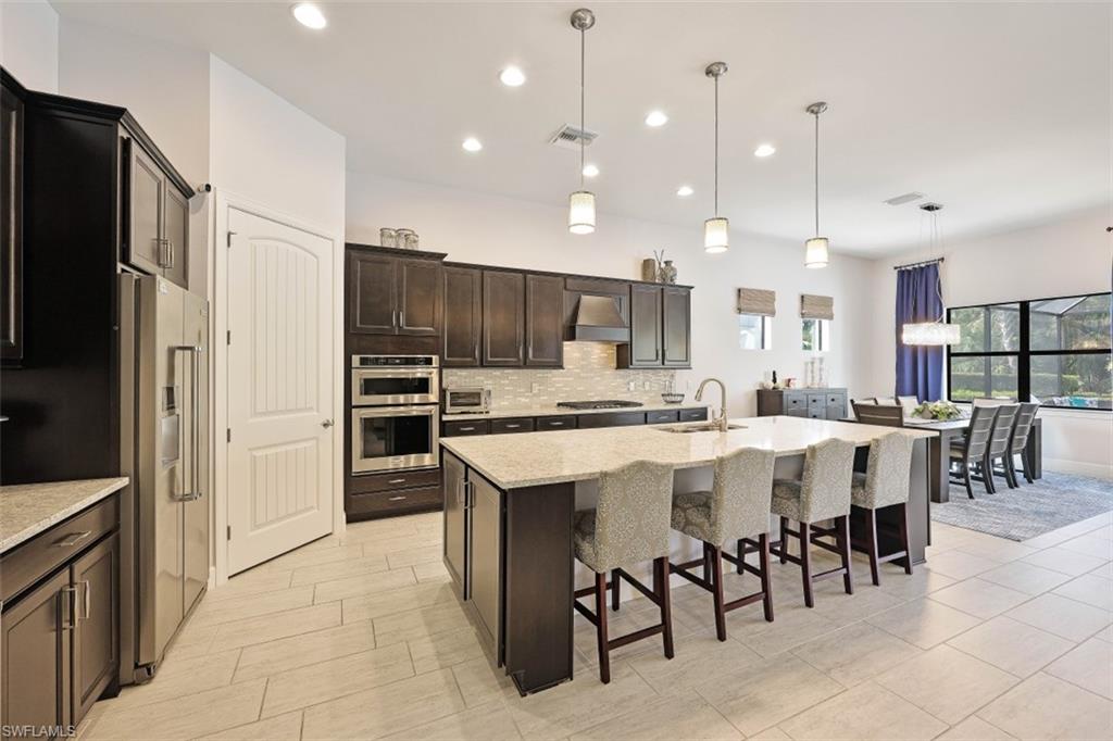 9431 Greyhawk Trail Naples, FL 34120 - Photo 6 of 50 a large kitchen with a table and chairs