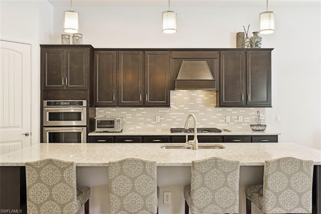 9431 Greyhawk Trail Naples, FL 34120 - Photo 8 of 50 a kitchen with stainless steel appliances granite countertop a sink and a stove