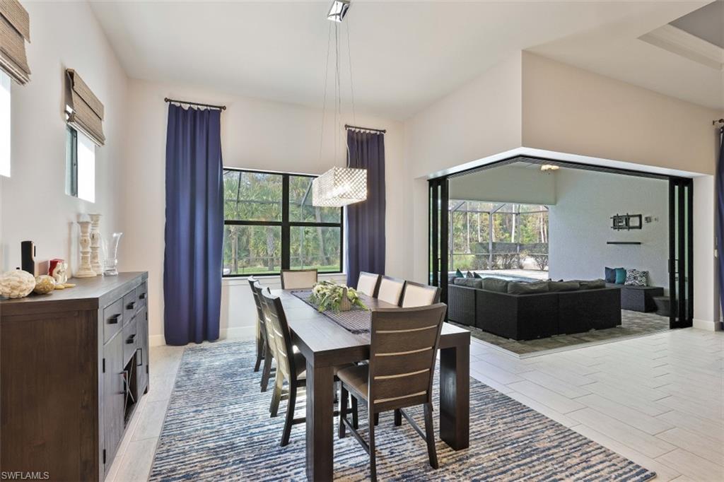 9431 Greyhawk Trail Naples, FL 34120 - Photo 9 of 50 a dining room with a wooden table and chairs