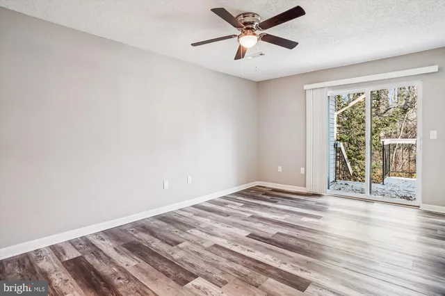 a view of room with a ceiling fan and wooden floor