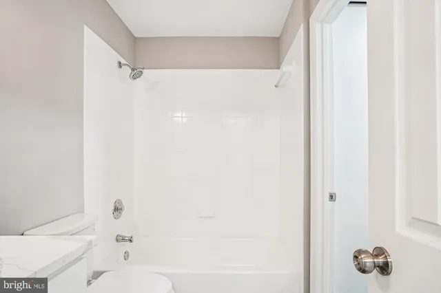 an empty room with ceiling fan and window