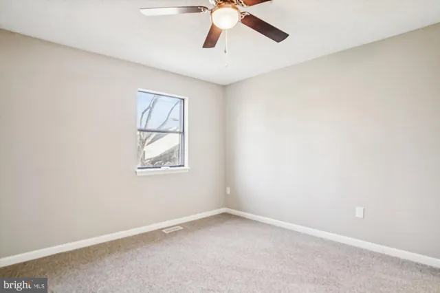an empty room with closet and a chandelier fan