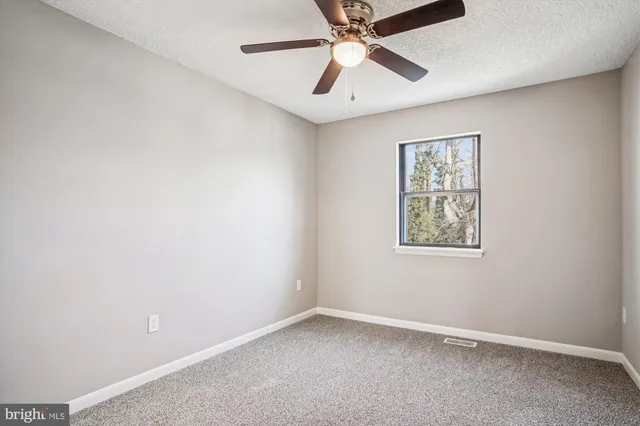 a view of an empty room with cabinet and door