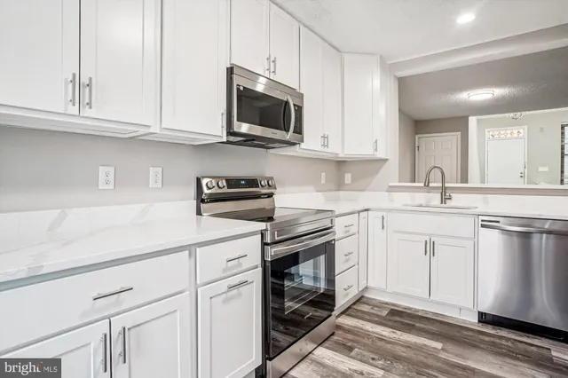 a kitchen with stainless steel appliances granite countertop a sink a stove a microwave and cabinets