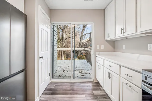 a hallway with white cabinets and wooden floor