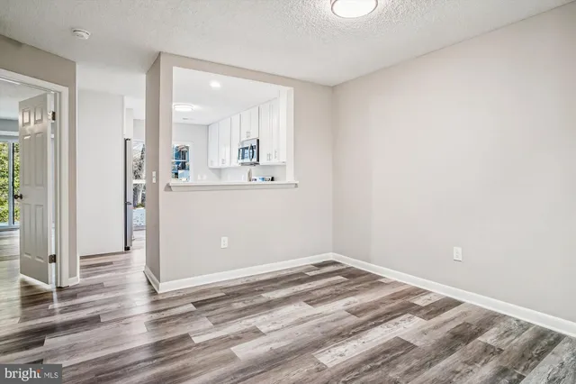 a view of a room with wooden floor and white walls