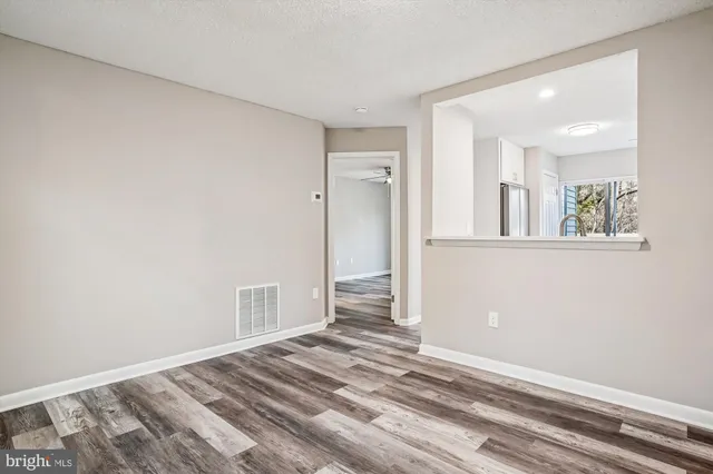 a view of a room with wooden floor and a bathroom