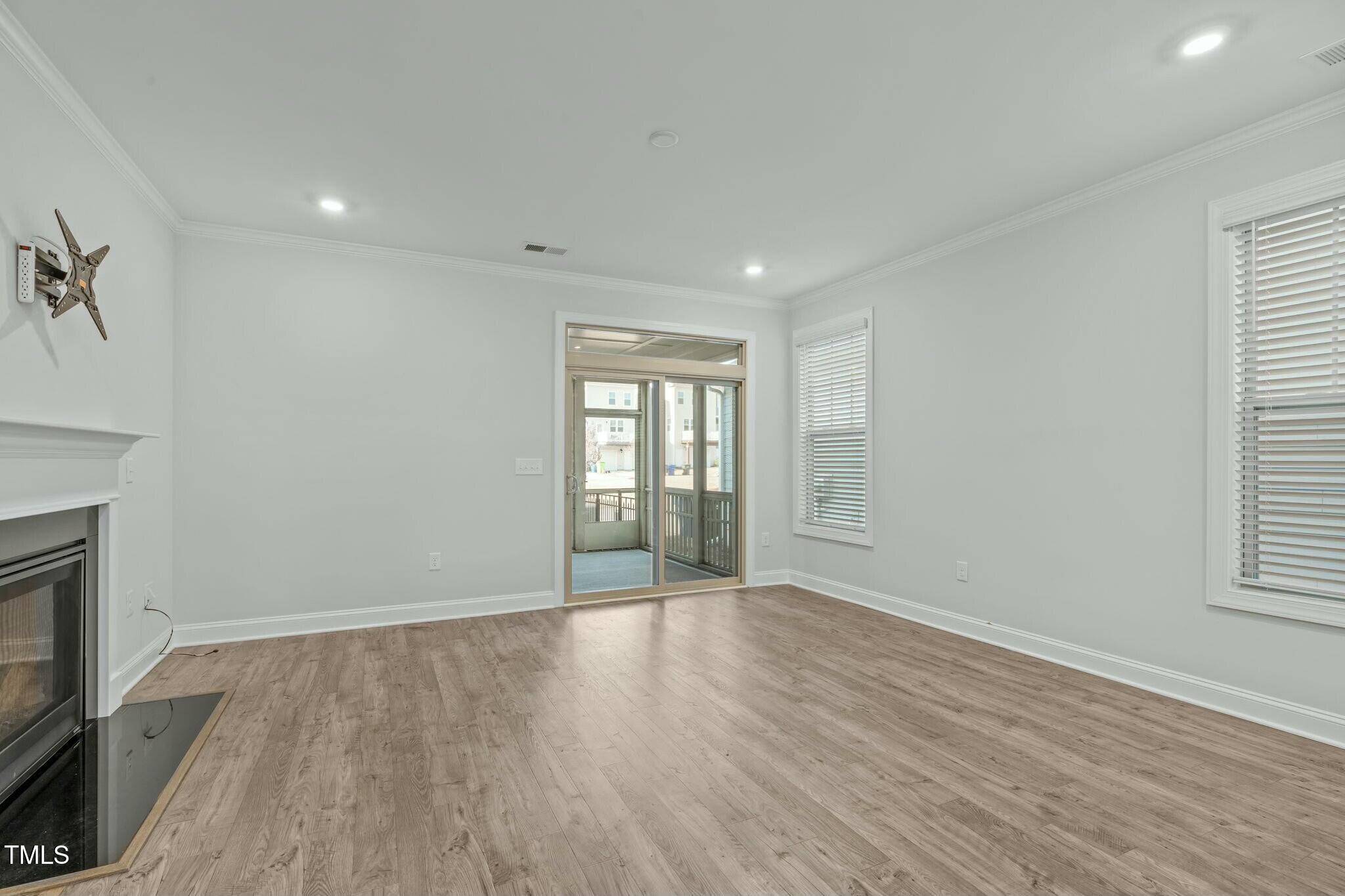 6417 Truxton Lane Raleigh, NC 27616 - Photo 14 of 47 a view of an empty room with wooden floor and a window