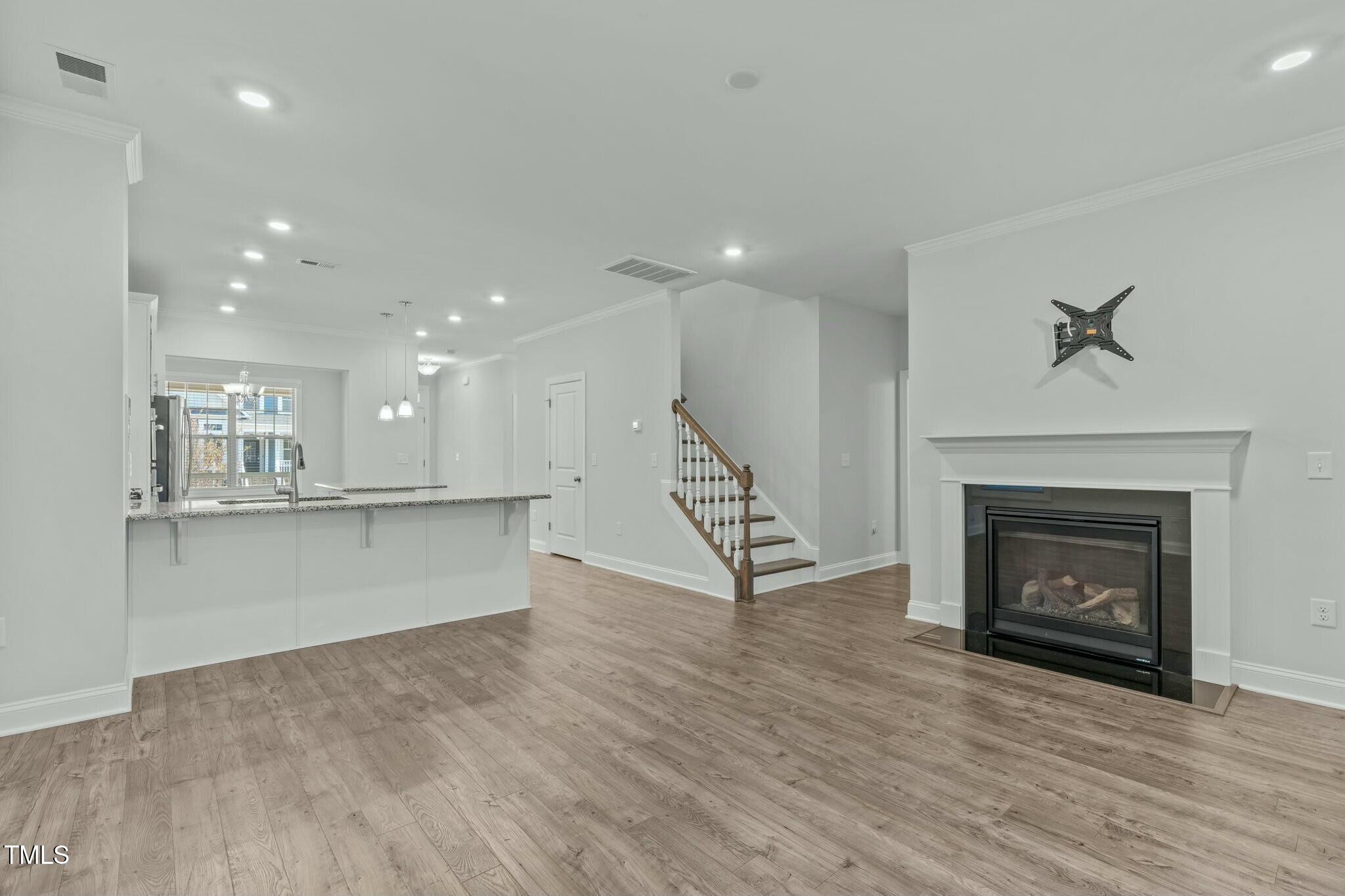 6417 Truxton Lane Raleigh, NC 27616 - Photo 16 of 47 a view of kitchen and fireplace with wooden floor