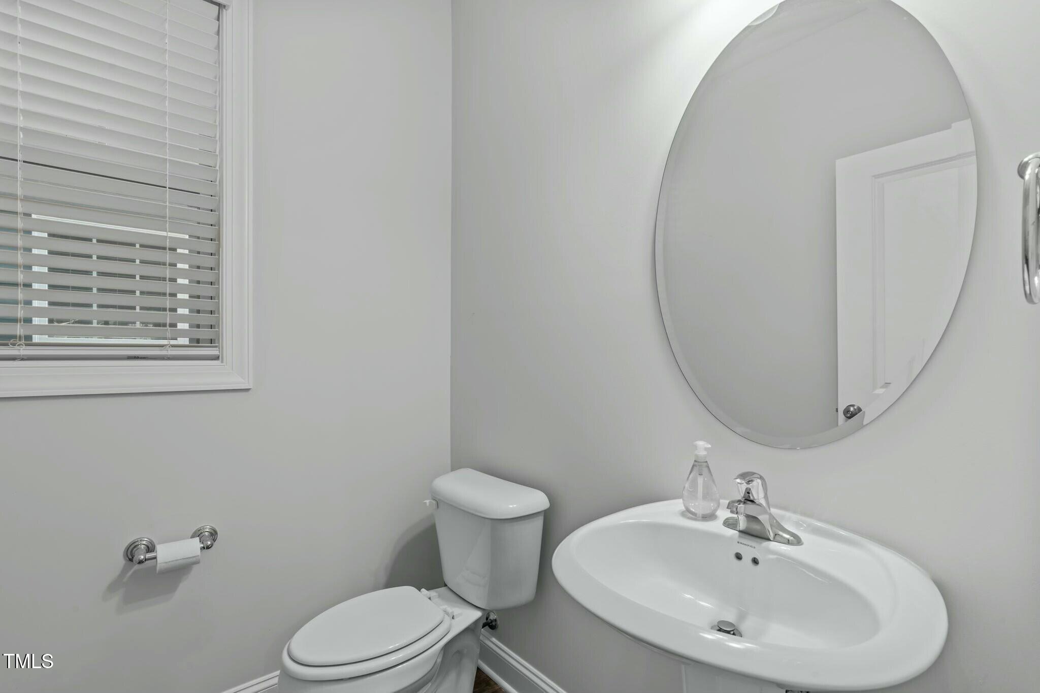 6417 Truxton Lane Raleigh, NC 27616 - Photo 18 of 47 a bathroom with a sink a toilet and a mirror
