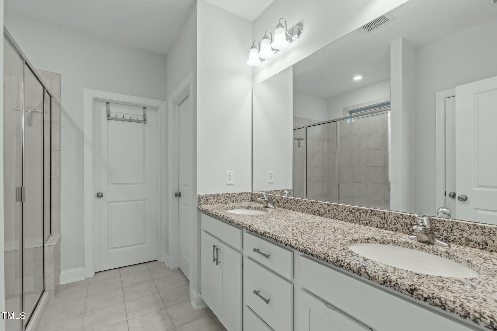 6417 Truxton Lane Raleigh, NC 27616 - Photo 24 of 47 a bathroom with a granite countertop sink and a mirror