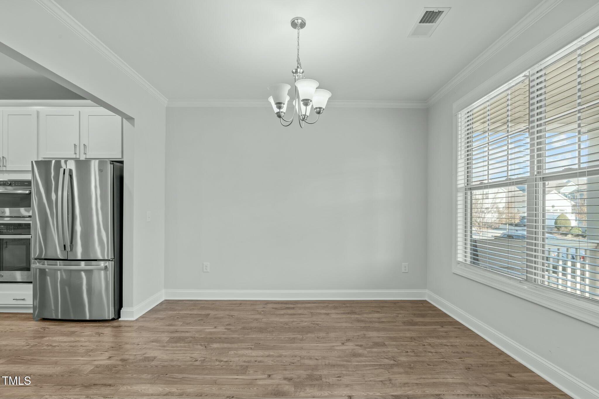 6417 Truxton Lane Raleigh, NC 27616 - Photo 6 of 47 a view of a kitchen with a ceiling fan refrigerator and wooden floor