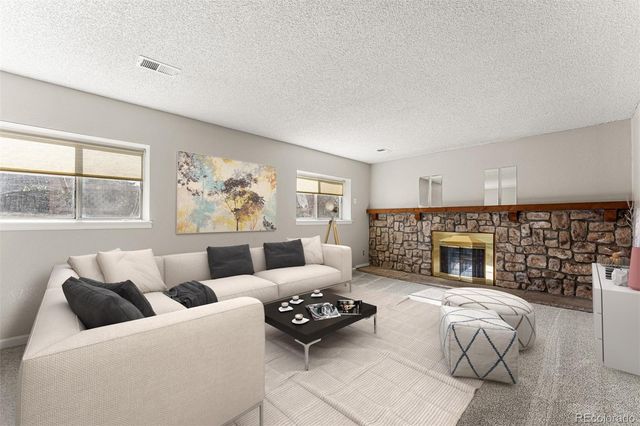 a living room with furniture large window and fireplace