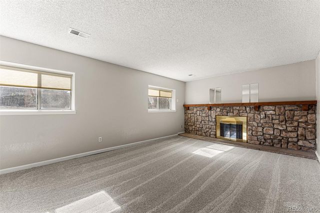 a view of an empty room with a fireplace and a window