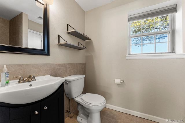a bathroom with a toilet a sink and mirror