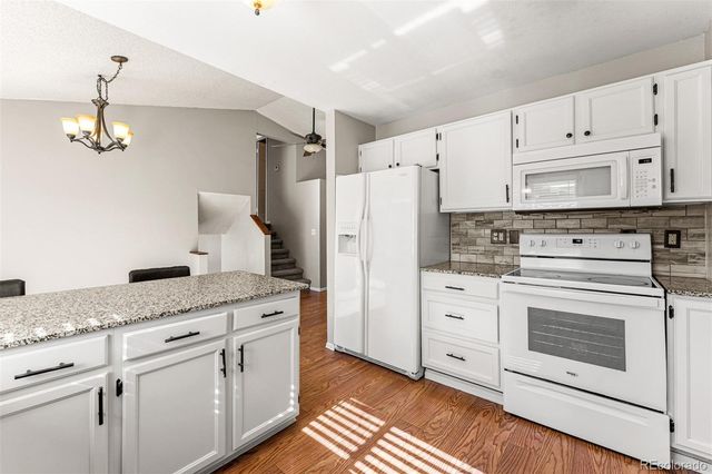 a kitchen with white cabinets and white appliances