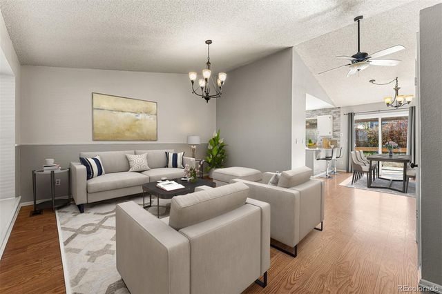a living room with furniture wooden floor and a chandelier