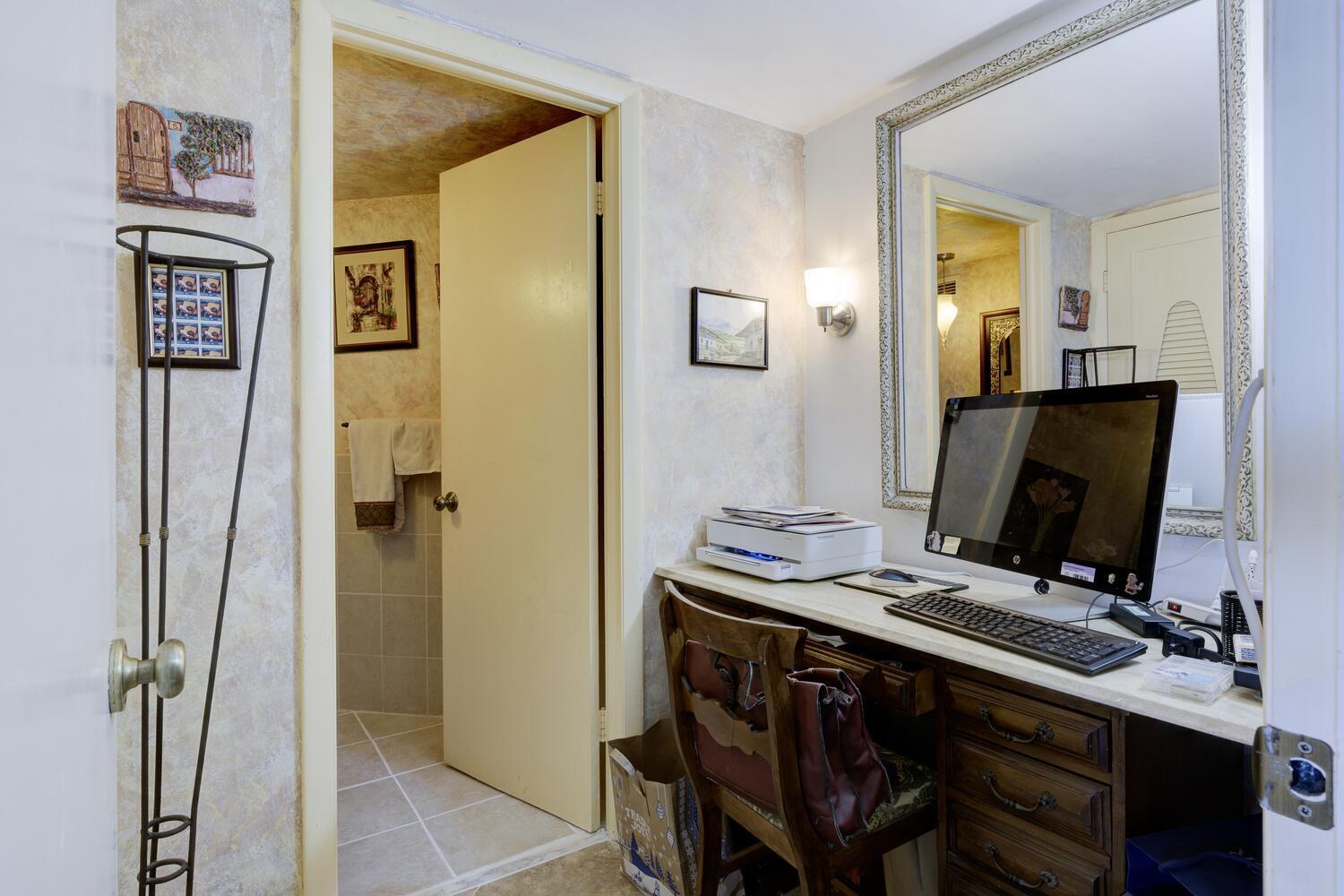 3800 Washington Road, Unit 1002 West Palm Beach, FL 33405 - Photo 13 of 20 a view of a workspace with furniture and flat screen tv