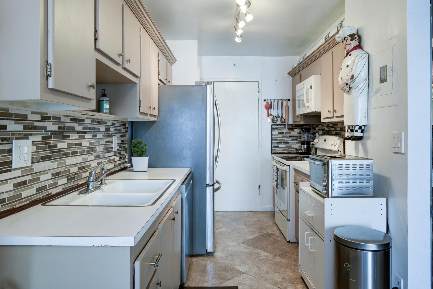 3800 Washington Road, Unit 1002 West Palm Beach, FL 33405 - Photo 7 of 20 a kitchen with stainless steel appliances a sink stove and refrigerator