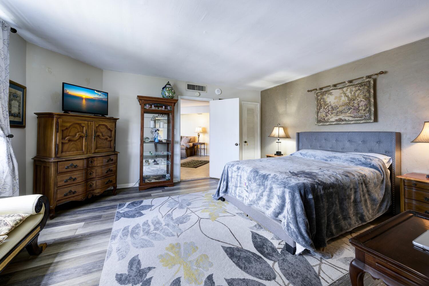 3800 Washington Road, Unit 1002 West Palm Beach, FL 33405 - Photo 10 of 20 a spacious bedroom with a bed and a television