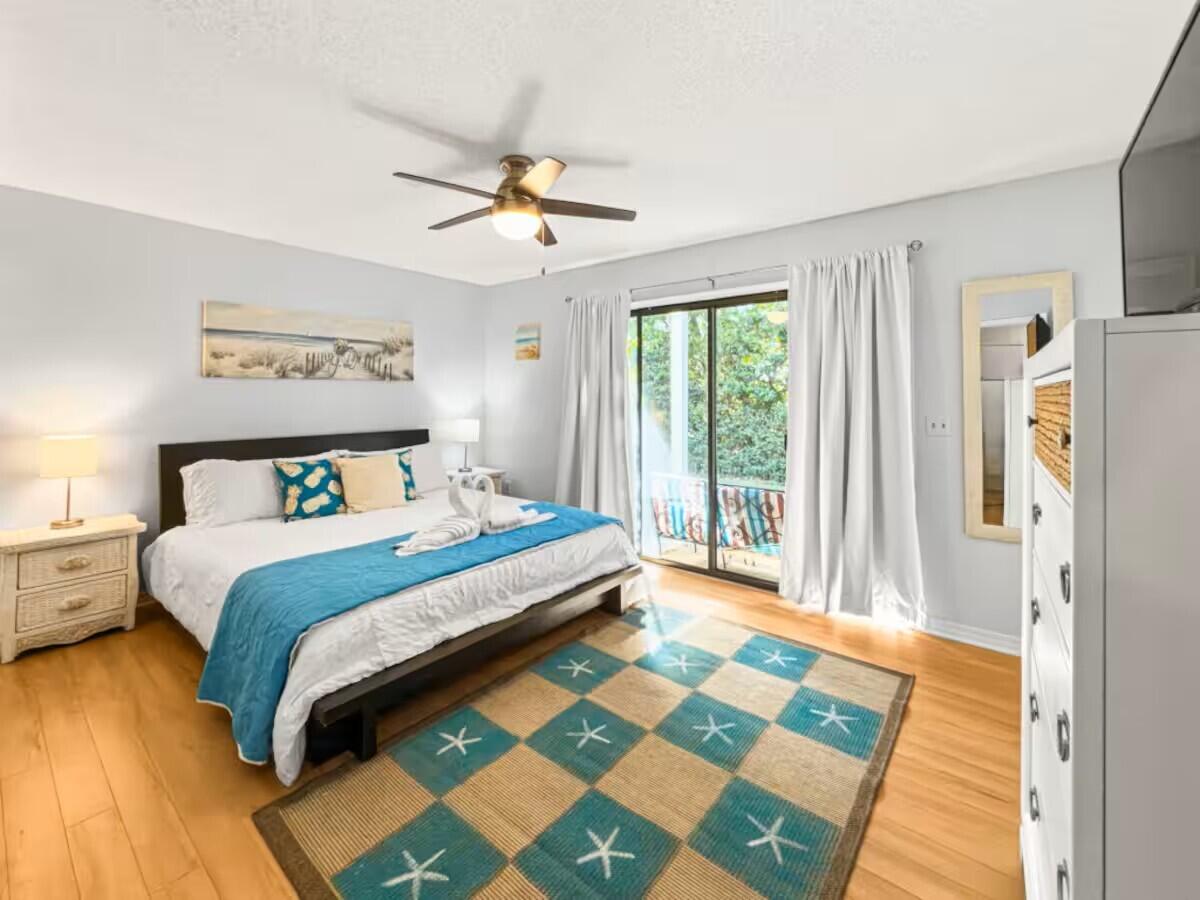 100 North Myrtle Drive, Unit 116 Santa Rosa Beach, FL 32459 - Photo 5 of 29 a bedroom with a bed lamp and a large window with wooden floor