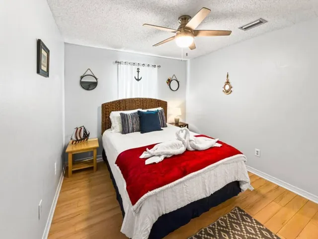 a bedroom with a bed and wooden floor