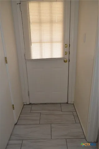a view of a small space with wooden floor and a window