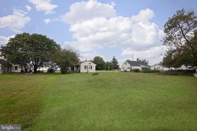 a view of a house with a big yard and large trees