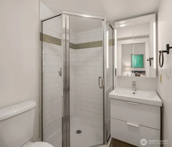 a bathroom with a shower a sink a toilet and mirror