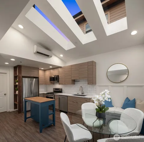 a kitchen with a table chairs a sink dishwasher and cabinets