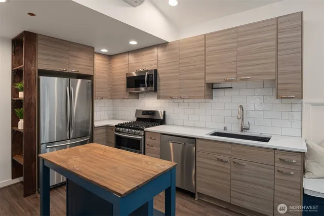 a kitchen with a sink a stove a refrigerator and cabinets