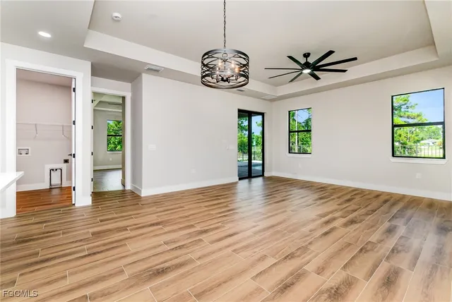 a view of an empty room with window and wooden floor