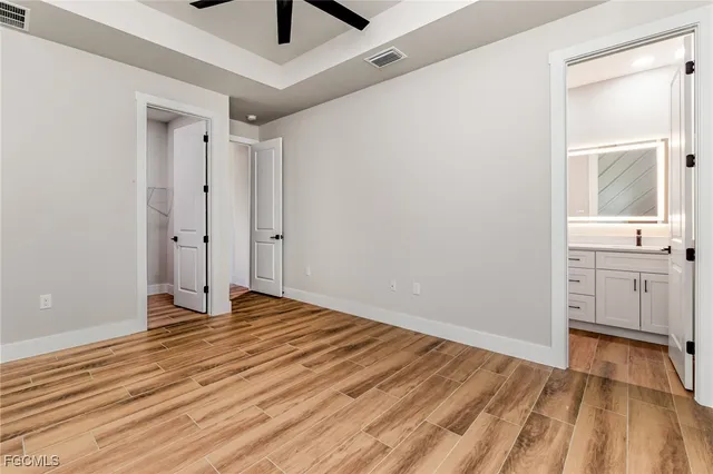 a view of a room with wooden floor and a ceiling fan