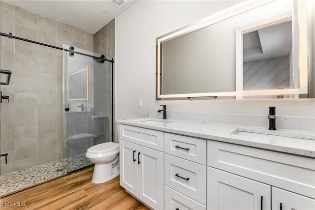 a bathroom with a sink a toilet and shower