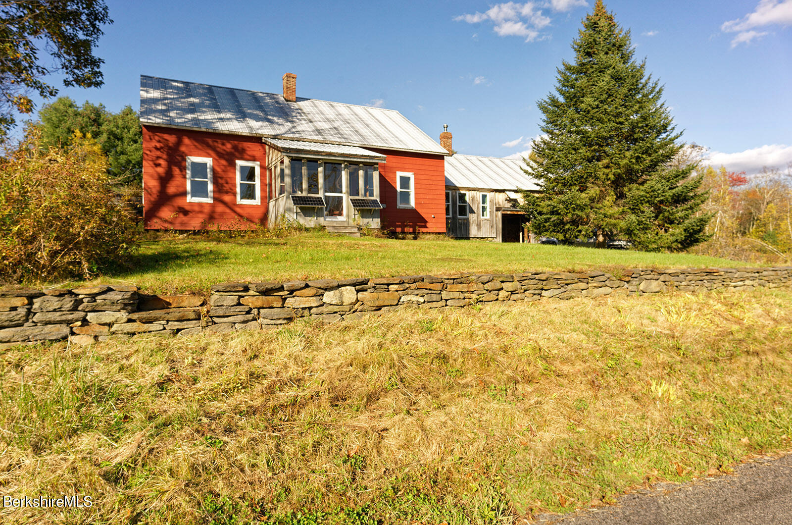 a front view of a house with a big yard and large trees