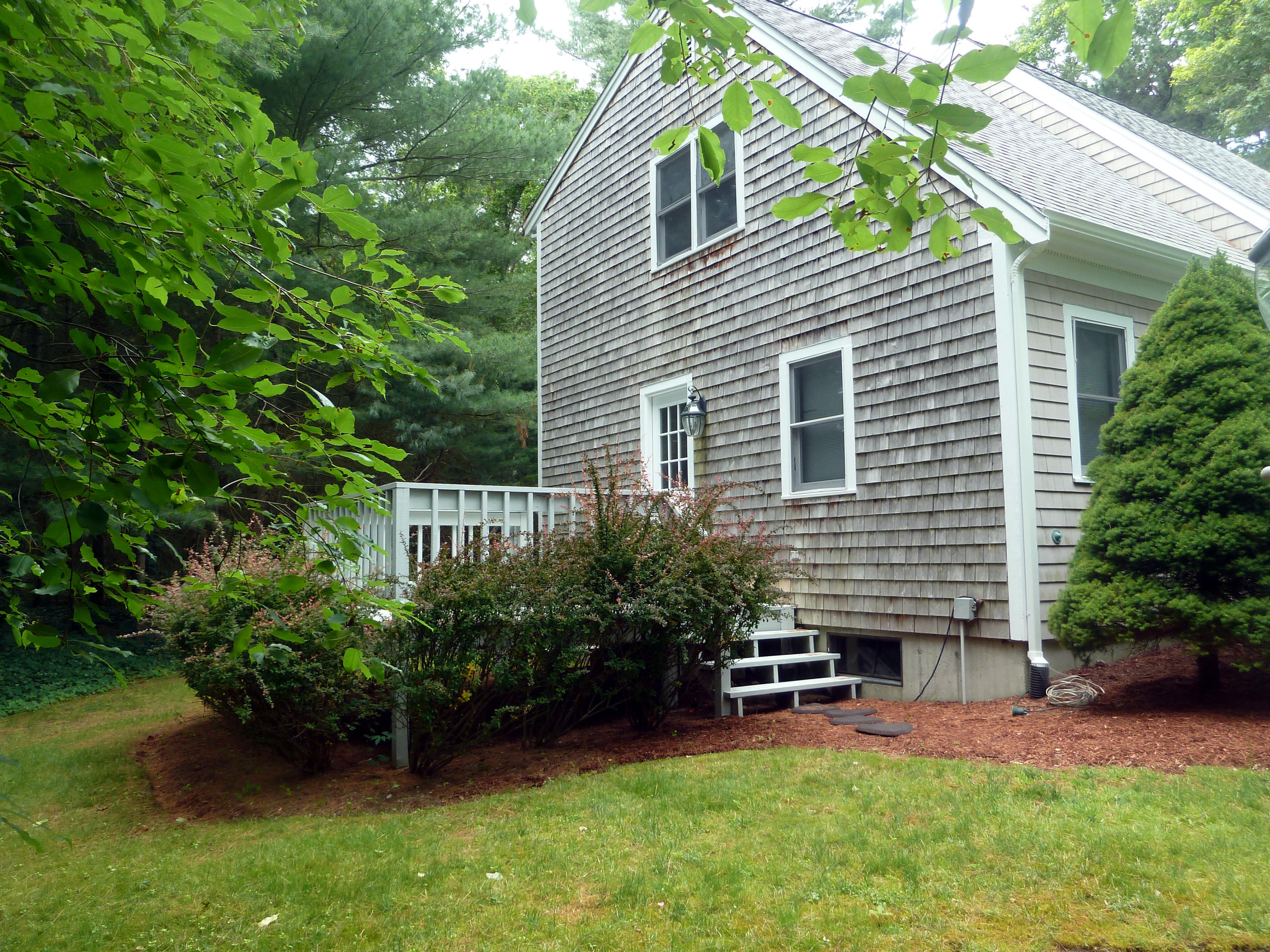 95 Sea Robin Road Osterville, MA 02655 - Photo 3 of 23 a backyard of a house with plants and outdoor seating