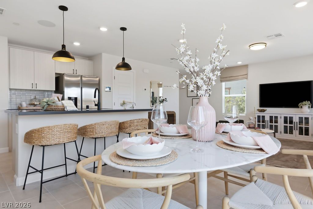 913 Cadence View Way Henderson, NV 89011 - Photo 16 of 46 Bright, open-concept kitchen and dining area features pendant lighting, a breakfast bar, and ample space for entertaining.
