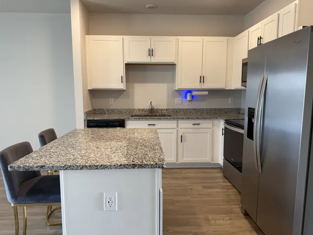 a kitchen with stainless steel appliances granite countertop a sink stove and refrigerator
