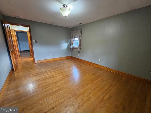 a spacious bathroom with a granite countertop sink a toilet and a mirror