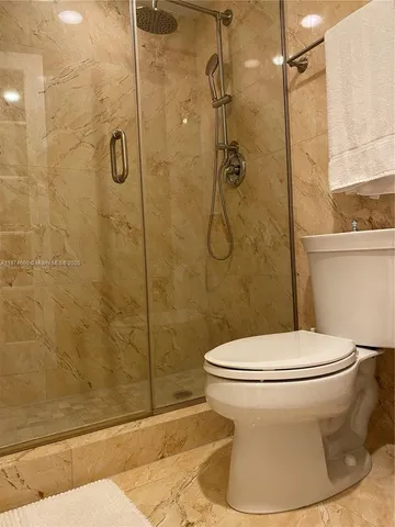 a white toilet sitting next to a shower