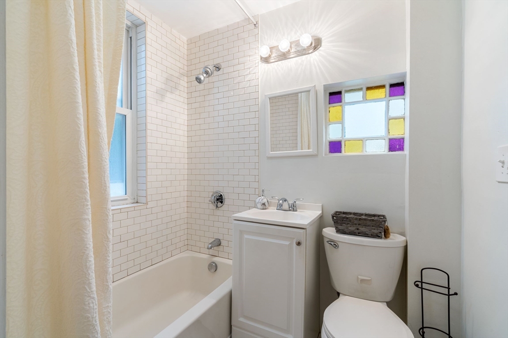 23 Goethe Street, Unit 1 Boston, MA 02132 - Photo 12 of 19 a bathroom with a sink a toilet and shower curtain