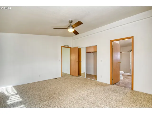 a view of a livingroom with a ceiling fan and window