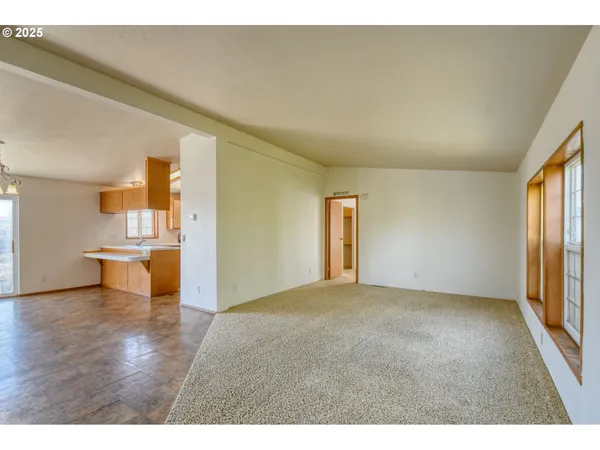 a view of empty room with wooden floor and windows