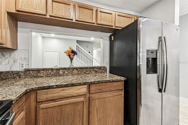 a kitchen with stainless steel appliances granite countertop a refrigerator and a sink