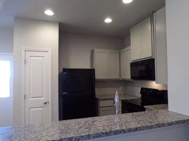 a kitchen with stainless steel appliances granite countertop a refrigerator and a sink