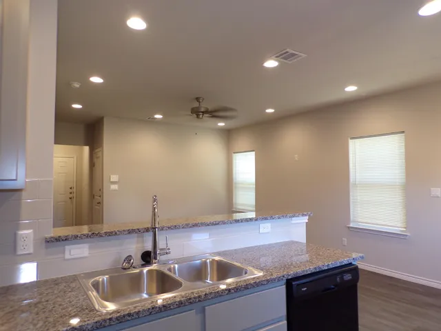 a kitchen with granite countertop a sink and a large mirror